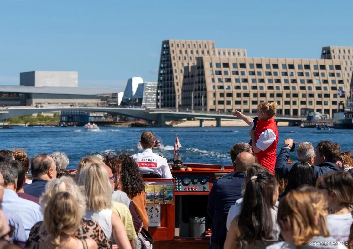 Guia explicant la ruta del Creuer pels Canals de Copenhagen a prop de l'estàtua de la Sireneta