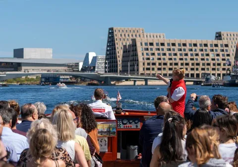 Guide erzählt die Geschichte der Kopenhagen Kanalrundfahrt nahe der Kleinen Meerjungfrau