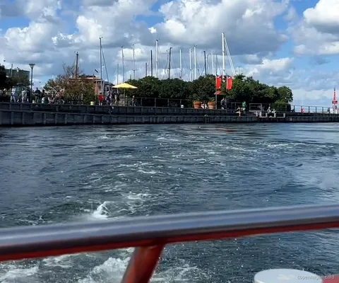 Łódź rejsu kanałami po Kopenhadze odpływająca z Ved Stranden obok historycznej zabudowy nabrzeża